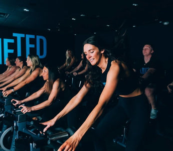 Group indoor cycling class in a fitness studio during a high-intensity spin workout