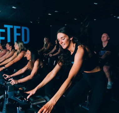Group indoor cycling class in a fitness studio during a high-intensity spin workout