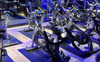 Indoor cycling studio with rows of commercial spin bikes set up for group fitness classes