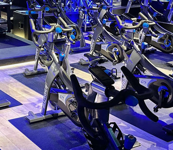 Indoor cycling studio with rows of commercial spin bikes set up for group fitness classes