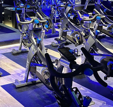 Indoor cycling studio with rows of commercial spin bikes set up for group fitness classes