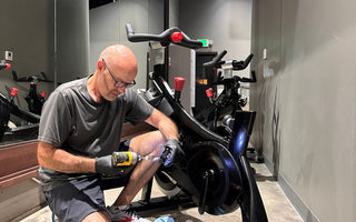 Indoor Cycle Pros technician Andrew Sandoval repairing a Stages SC2 indoor spin bike at a cycling studio