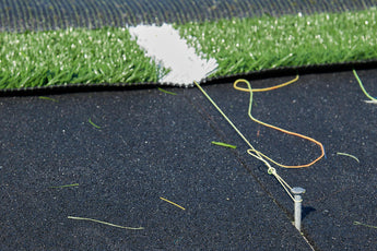 Close-up of synthetic turf edge laid on REGUPOL abzorb recycled rubber shock pad