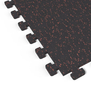Close-up of the puzzle-edge interlock on a Firestorm Red REGUPOL aktivlok rubber gym tile showing red flecks on a black base