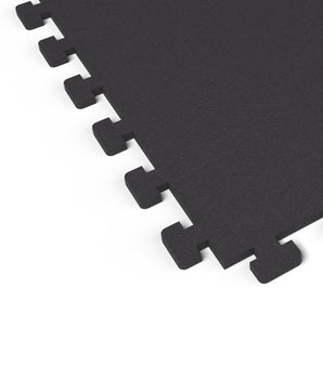 Close-up of the puzzle-edge interlock on a Jet Black REGUPOL aktivlok rubber gym tile showing a solid black surface
