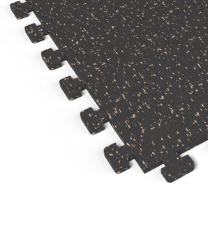 Close-up of the puzzle-edge interlock on a Titan Tan REGUPOL aktivlok rubber gym tile showing tan flecks on a black base